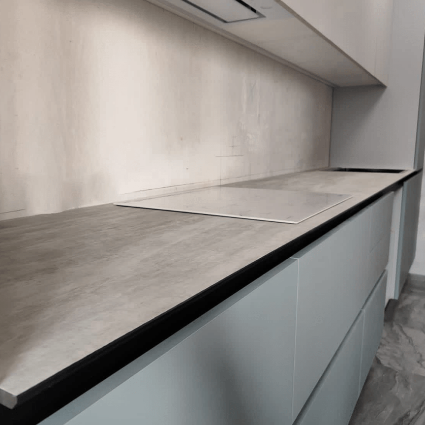 Тонкая столешница из HPL компакт пластика серого цвета в современной кухне, устойчива к влаге и ударам, стильное решение для интерьера.