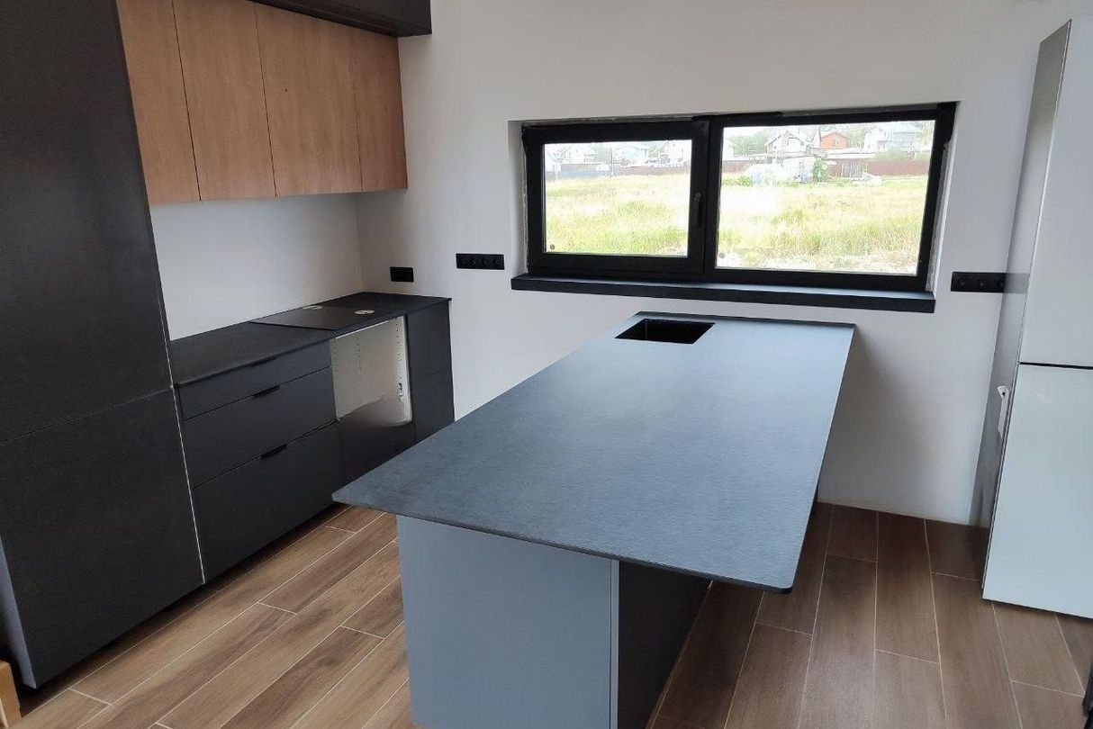 Кухонный остров со столешницей из HPL компакт пластика темно-серого цвета, современный интерьер, устойчива к влаге, ударам и царапинам.